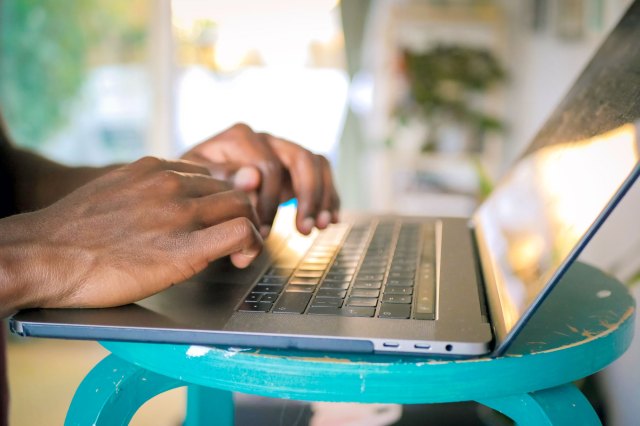 An image of a person typing on a laptop