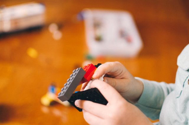 A child attempts to separate LEGO bricks