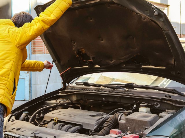 An image of a man putting up the hood of a car