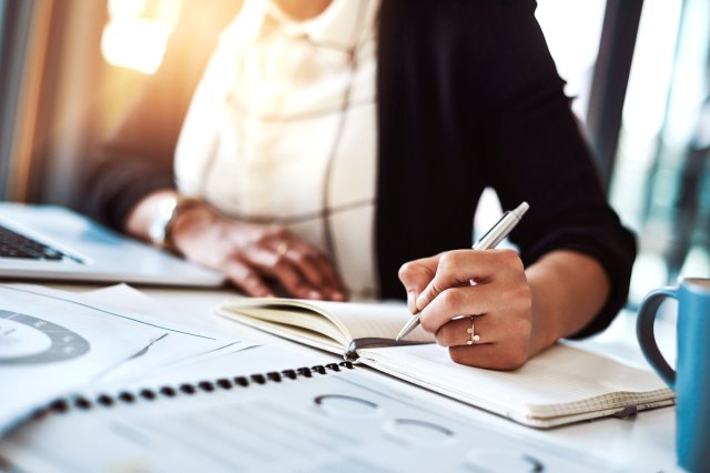 An image of a woman writing in a notebook