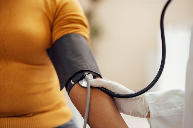 An image of a woman getting her blood pressure checked by a doctor