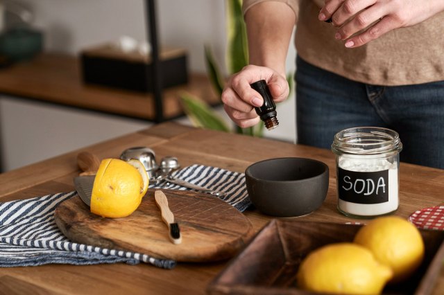 An image of a person adding essential oil to the bowl with DIY cleaning product