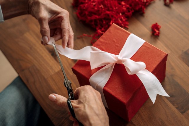 An image of a person cutting a piece of paper with scissors