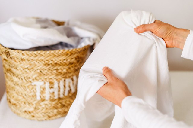 An image of a person holding a white shirt