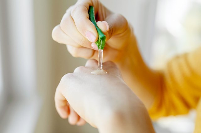 An image of a person squeezing aloe onto their hand