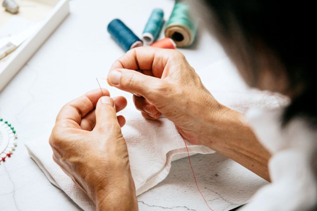 An image of a person threading a needle