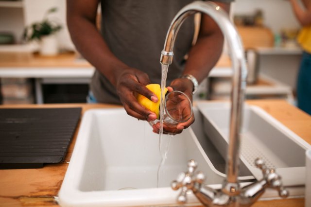 An image of a man washing a glass with a sponge