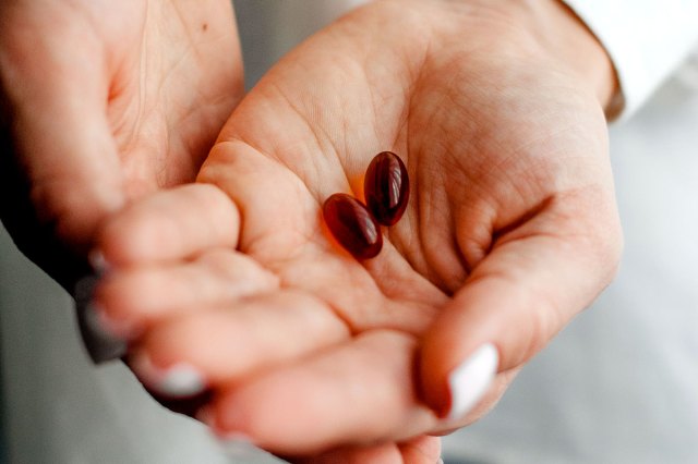 An image of two pills in the palm of a person's hand