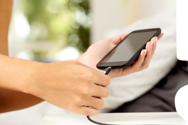 An image of a person plugging in a cell phone