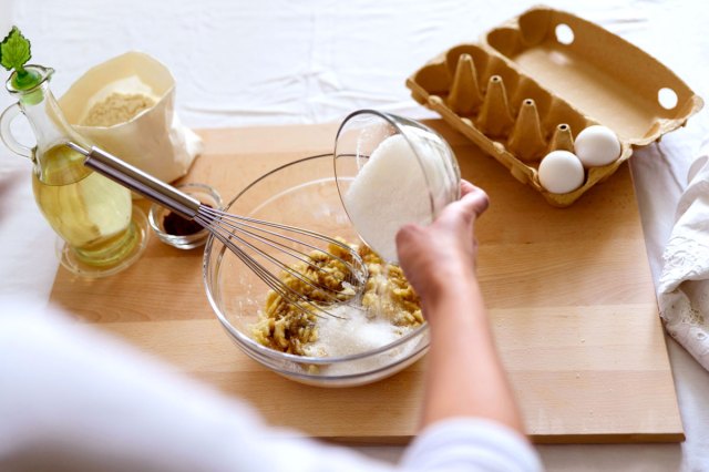 An image of sugar being poured into a mixing bowl