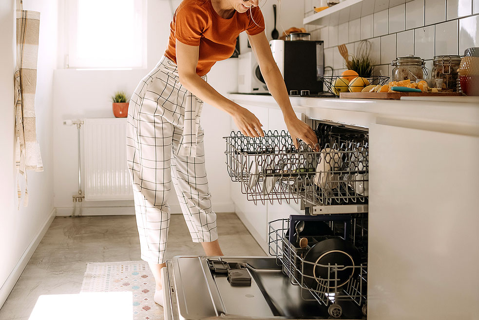 An image of a woman loading the dishwasher