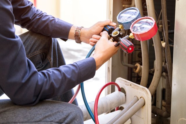 An image of a man holding measuring equipment for an HVAC