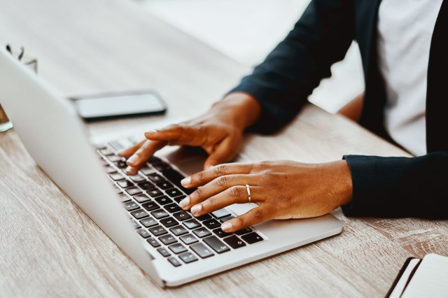 An image of a man typing on a laptop