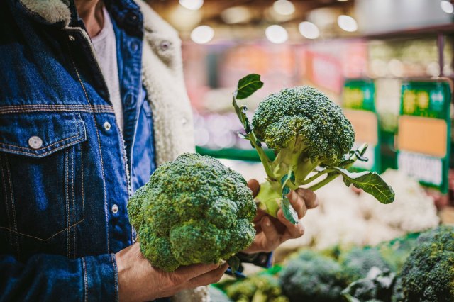 An image of a person holding stalks of broccoli