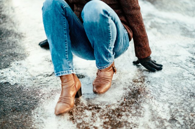 An image of a woman fallen down on icy street in winter