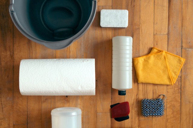 An image of a a wooden floor with various cleaning items on top of it