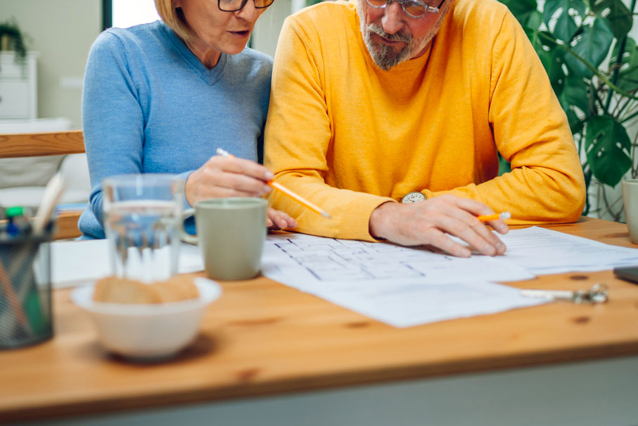 An image of a woman and a man sitting at table looking over paperwork