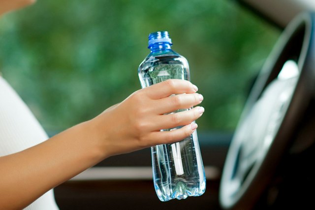 An image of a hand holding a plastic water bottle