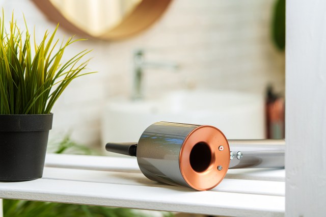 An image of a hairdryer on a white wooden table