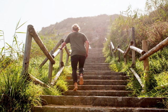 An image of a woman walking up outdoor stairs