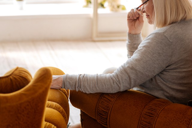 An image of a woman sitting in a comfortable chair next to an empty chair