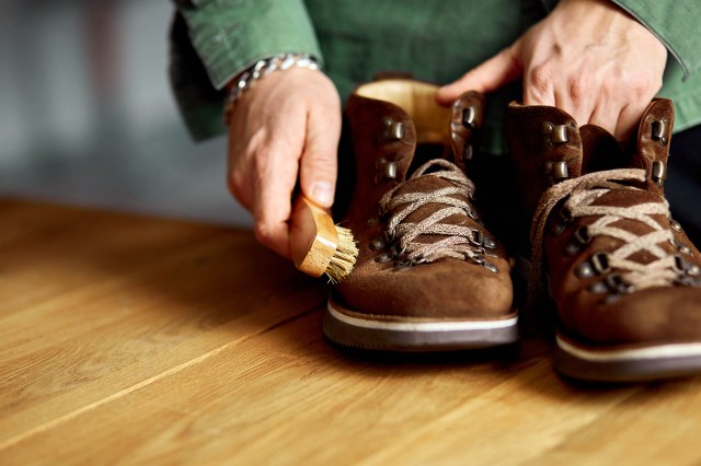 An image of a person dry cleaning a pair of shoes with a brush