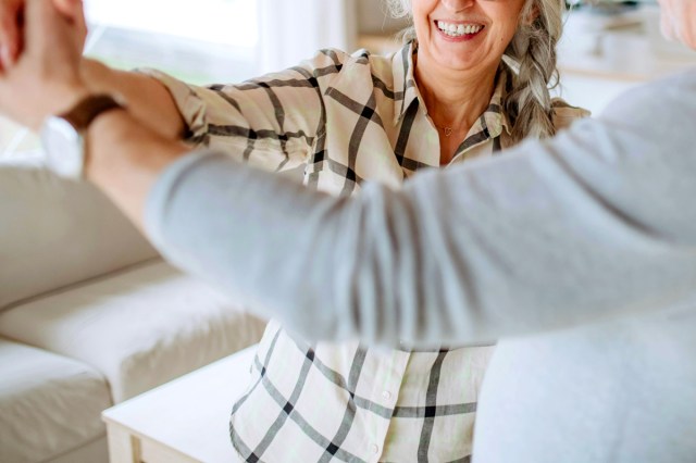 An image of a woman and a man dancing in a living room