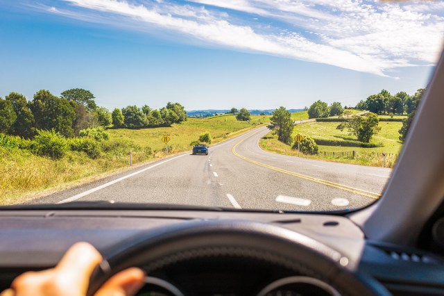 An image from the driver's seat of a car, looking out on the open road