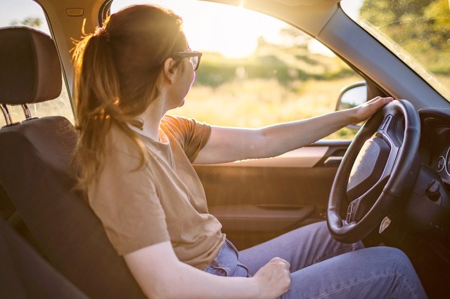 An image of a woman sitting in the driver's seat of a car