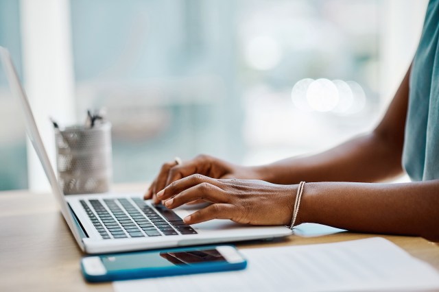 An image of a person typing on a laptop