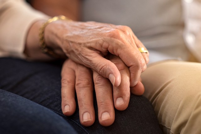 An image of a woman holding a man's hand