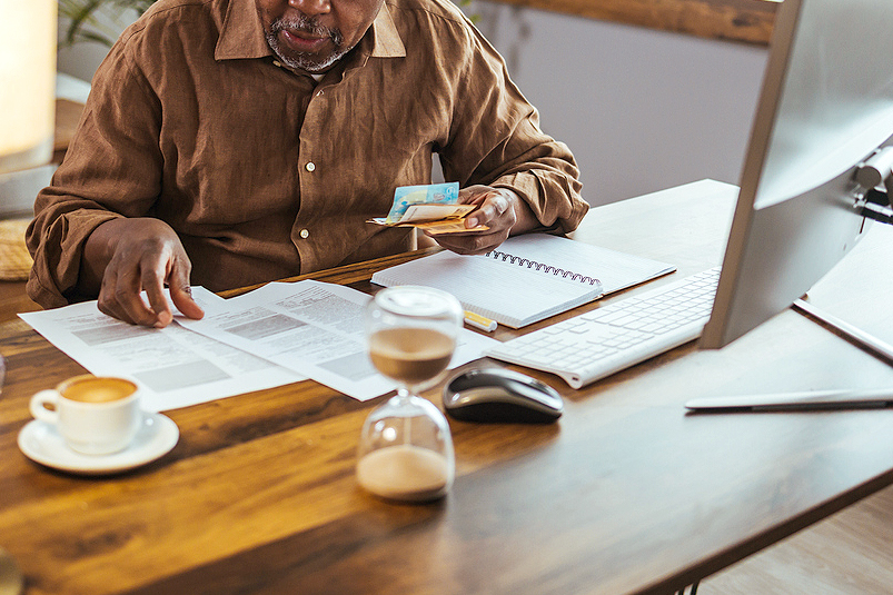 An image of a man sitting at a desk looking at paperwork