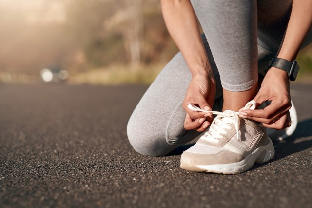 An image of person outside bendt down and tying a sneaker