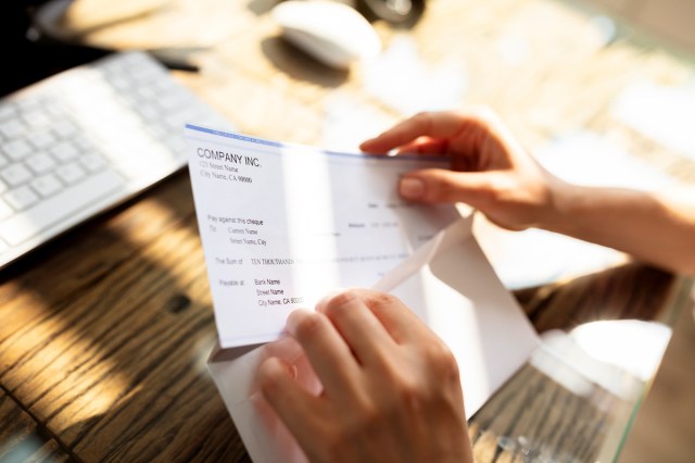 Person pulling a bill from an envelope