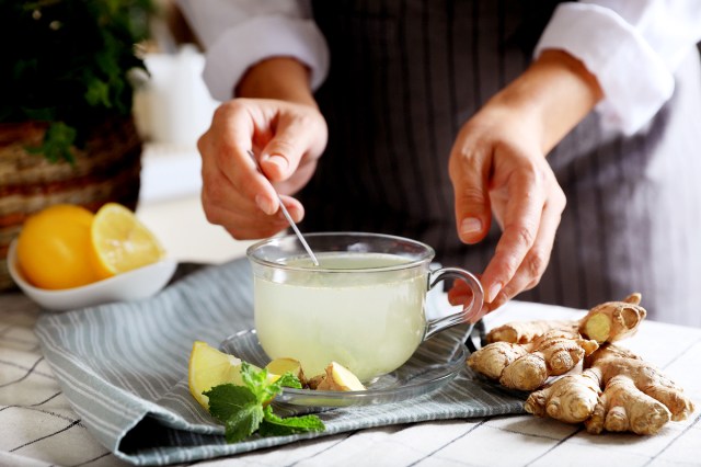 An image of a person stirring a mug of ginger tea