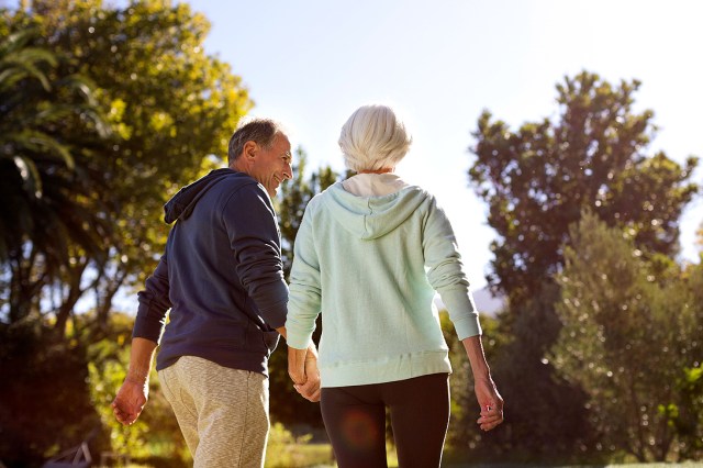 An image of a man and a woman holding hands outside