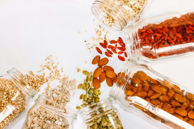 An image of jars of nuts an seeds spilling out
