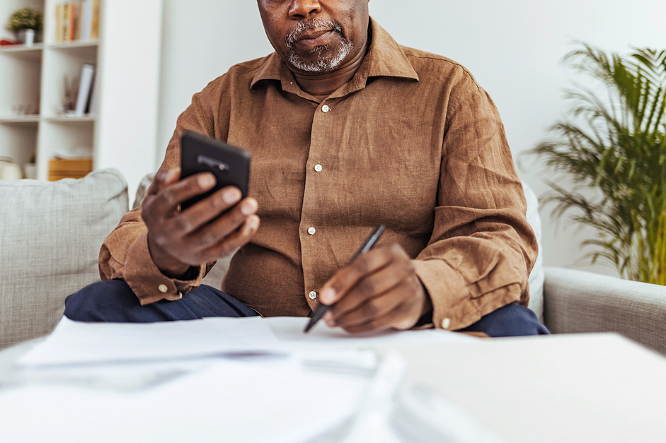 An image of a man working at home using smart phone