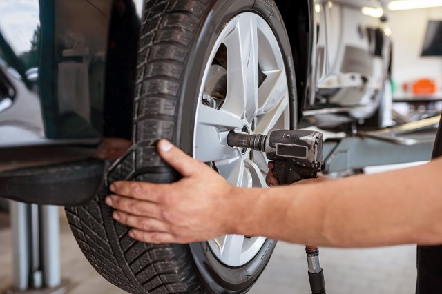 An image of a mechanic changing a tire