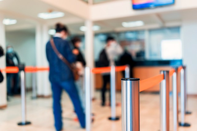 An image of a woman waiting in line at a bank