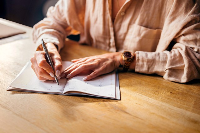 An image of a person writing in a calendar