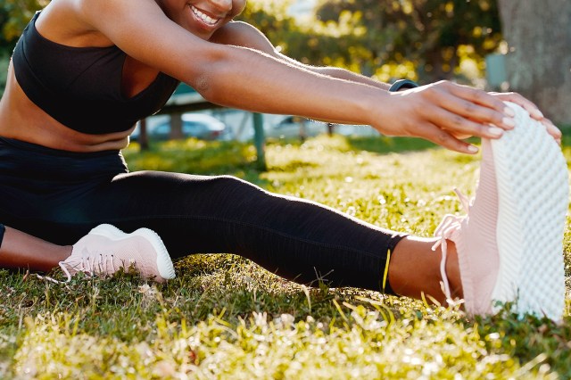 An image of a woman stretching on the grass