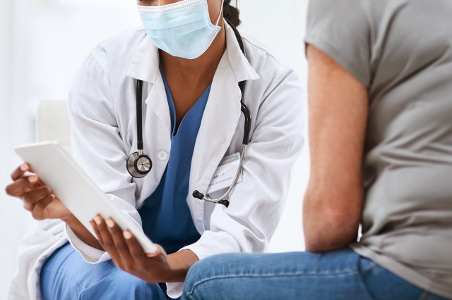 An image of a doctor showing a patient something on a tablet