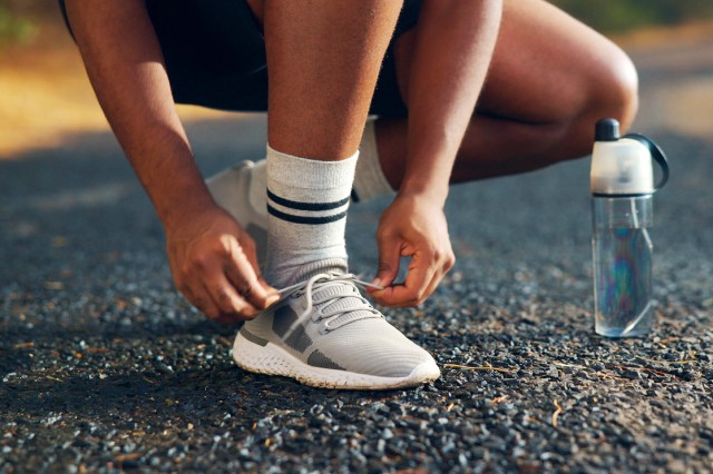 An image of a person tying their shoes