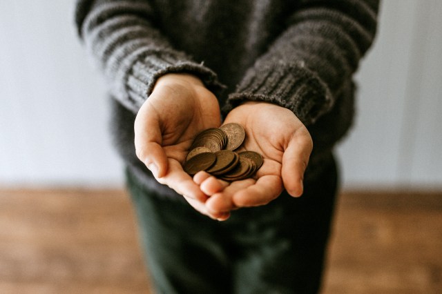 An image of coins in a person's palms