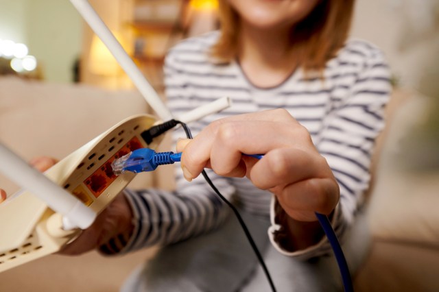 An image of a woman plugging in a router