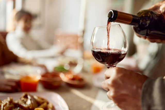 An image of a glass of red wine being poured