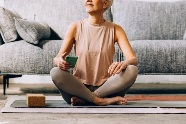 An image of a woman sitting crossed-leg on a yoga mat