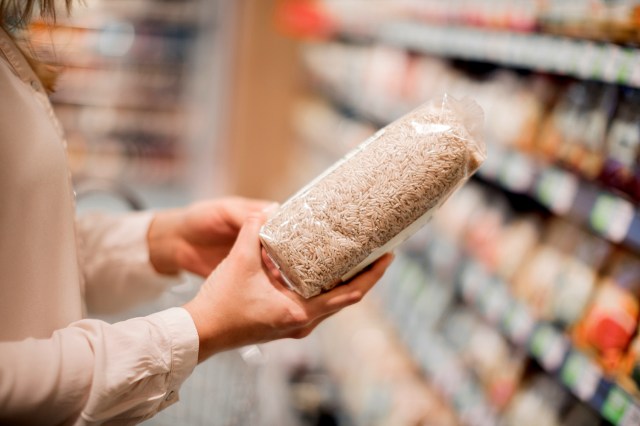An image of a woman holding a bag of brown rice