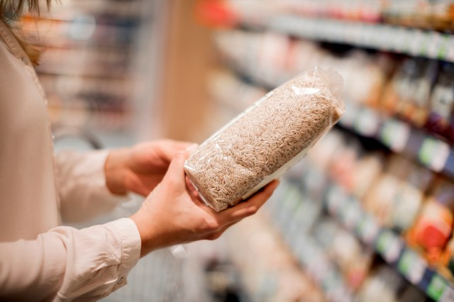 An image of a woman holding a bag of brown rice